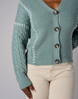 Seafoam cardigan with contrast whipstitch trim and button front closure.